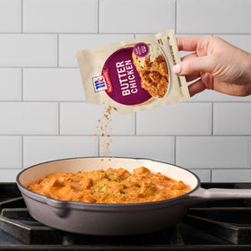 McCormick Butter Chicken stovetop-cooking in a simmering pan.