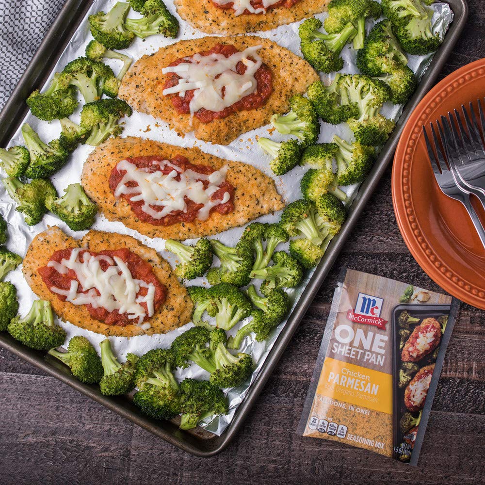Raw chicken and broccoli on a pan seasoned with McCormick mix.
