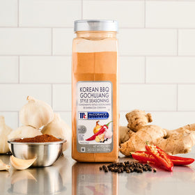 Bottle pouring over grilled shrimp to emphasize craveable, balanced heat.
