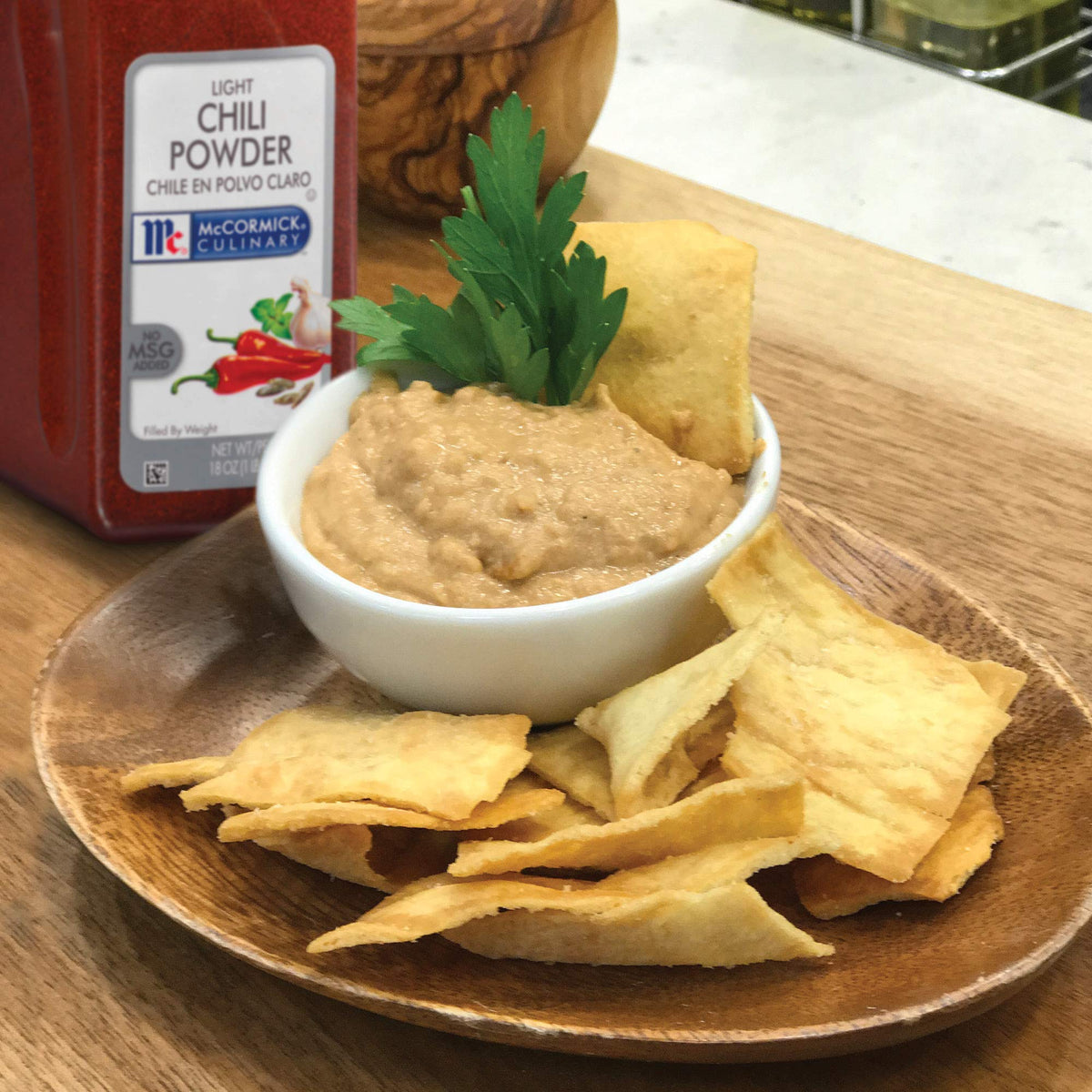 Ground spice close up shows earthy aroma and color of McCormick Culinary Light Chili Powder.