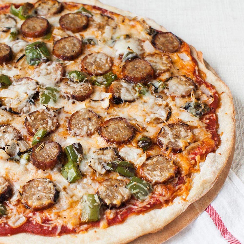 Pizza being seasoned with McCormick Grill Mates roasted garlic and herb