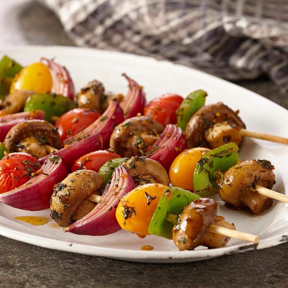 Bottle with seasoning creating a savory crust on grilled meat
