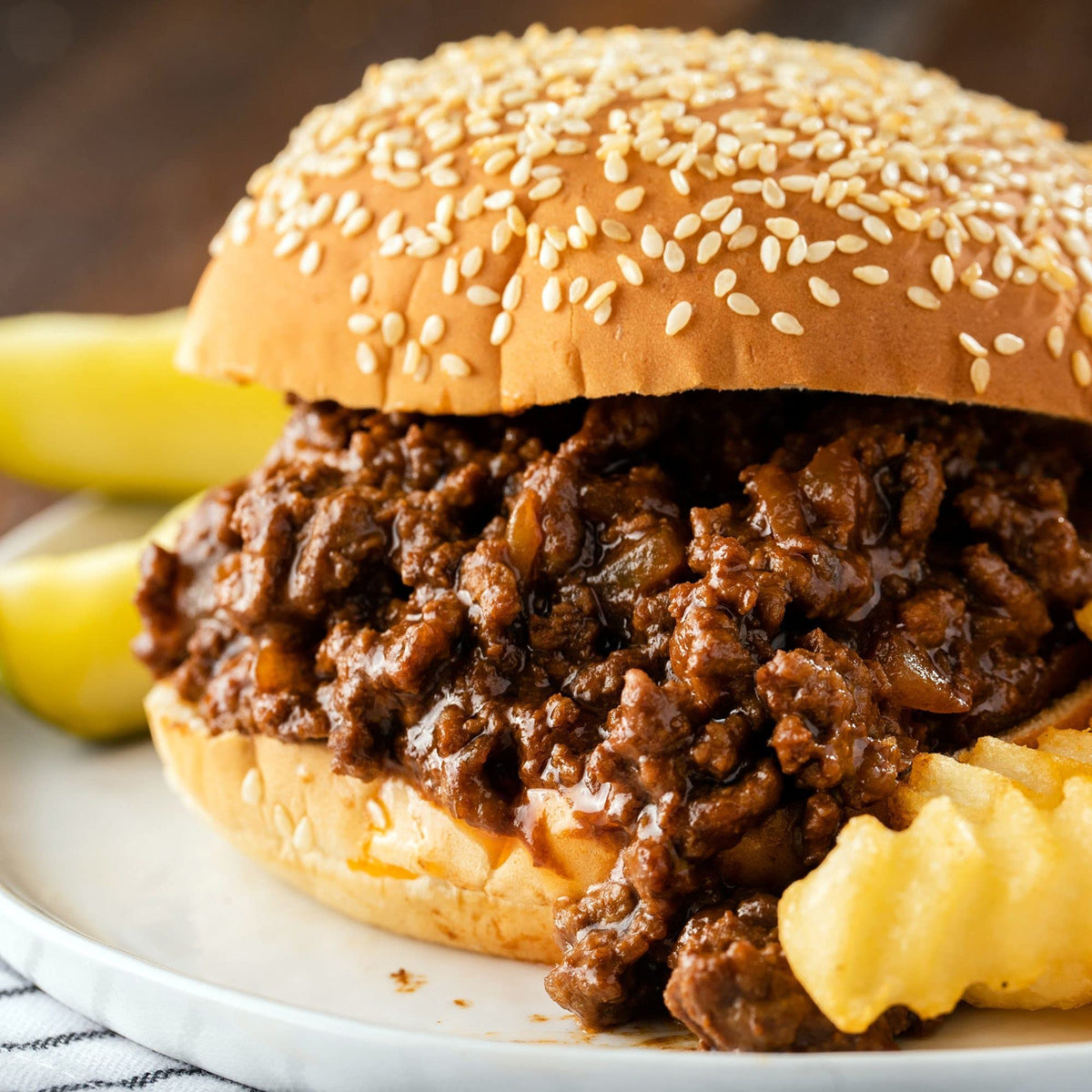 Pouring McCormick Sloppy Joes Seasoning Mix into a skillet for easy prep.