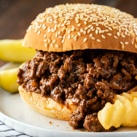 Pouring McCormick Sloppy Joes Seasoning Mix into a skillet for easy prep.