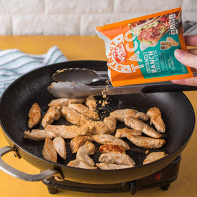 Close-up spoon dusting seasoning adds tangy ranch kick.