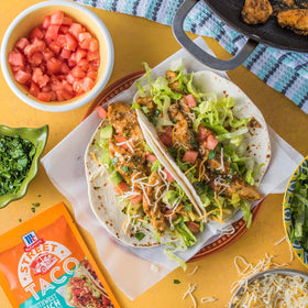 Tortillas ready to be filled with saucy chicken and toppings.