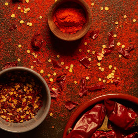 Open jar of MEROPS paprika pouring into a pan for color and aroma.
