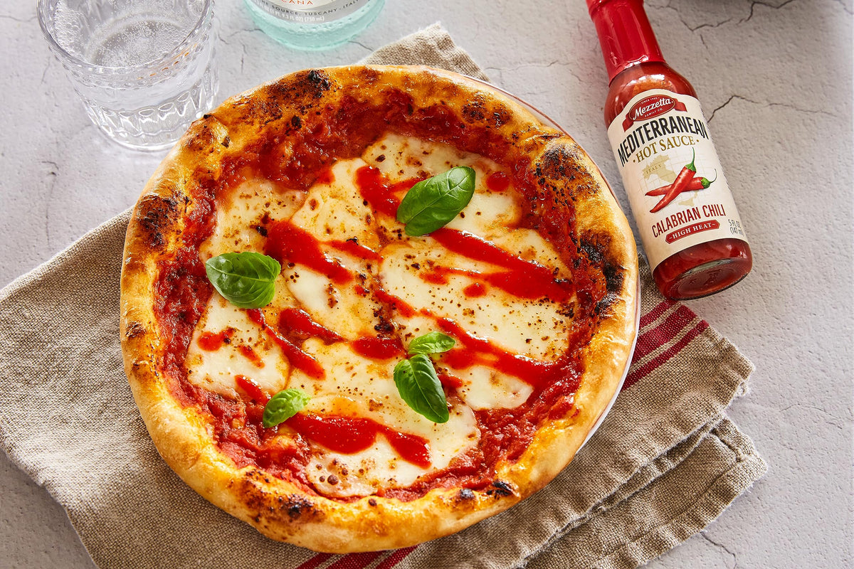 Mezzetta hot sauce sampler trio jars on white surface suggest premium assortment.