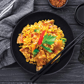 Mi Sedaap noodles-in-pan highlights swift stir-fry preparation and aroma.