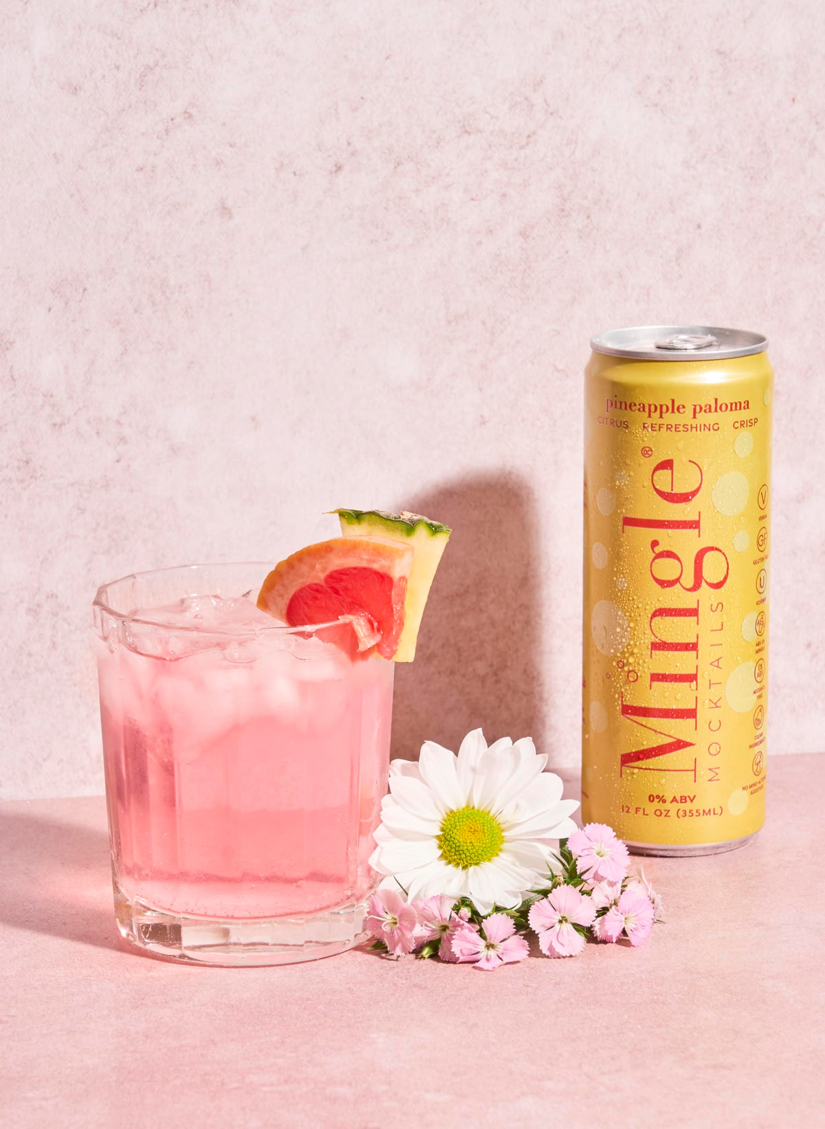 Mingle Mocktails Pineapple Paloma ingredients closeup, vibrant fruit juices and botanicals.