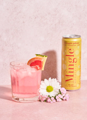 Mingle Mocktails Pineapple Paloma ingredients closeup, vibrant fruit juices and botanicals.