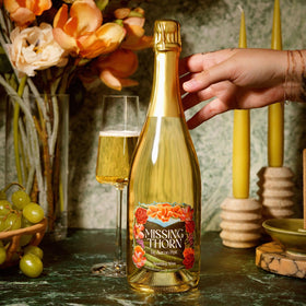 Pouring Missing Thorn Sparkling White NA Riesling with bubbles in a glass for entertaining.