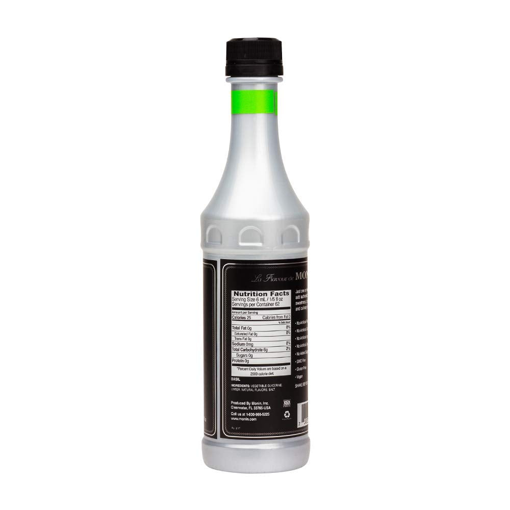 Monin Basil flavor concentrate being poured into a glass for refreshing beverages.