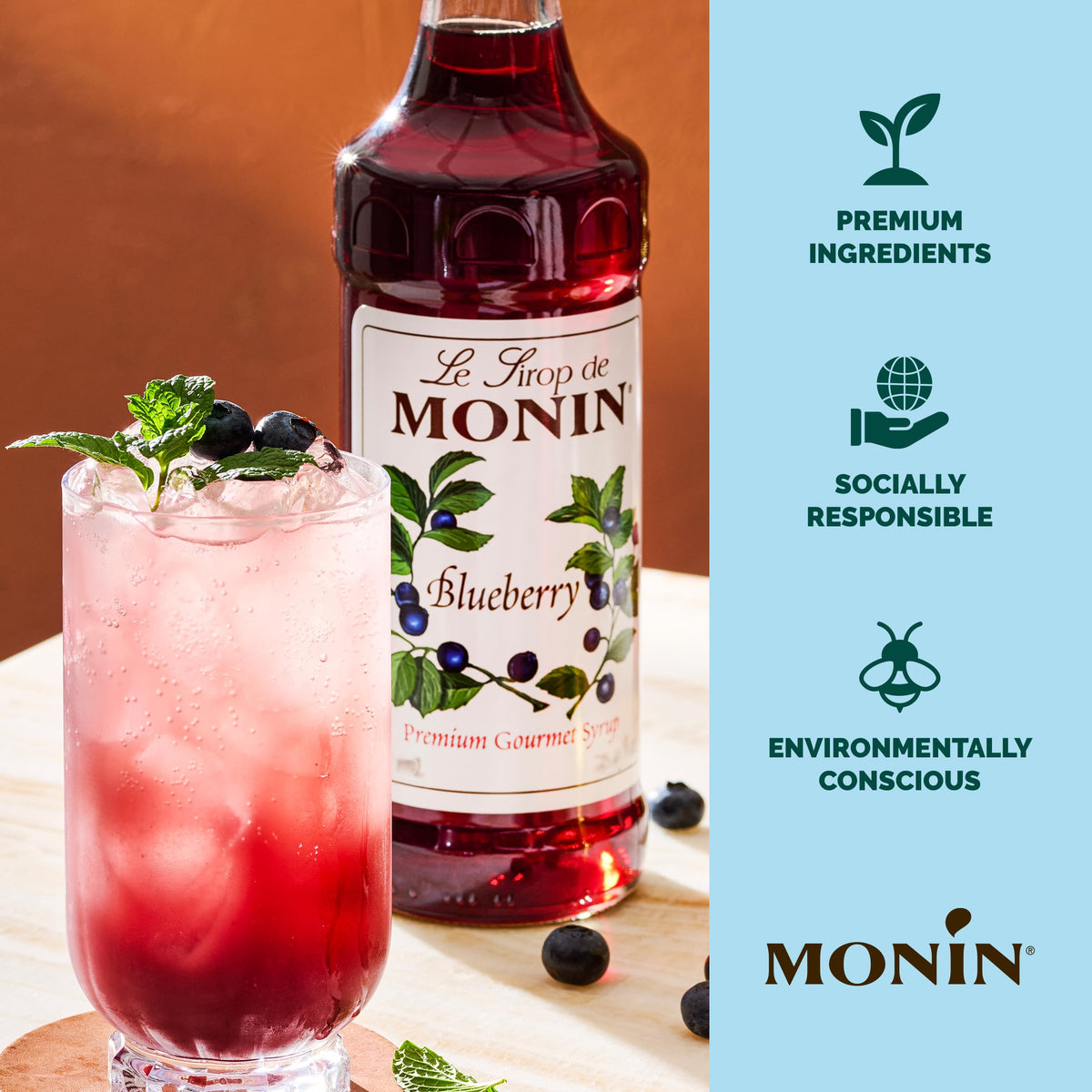 Monin Blueberry Syrup label beside a vibrant blueberry cocktail.