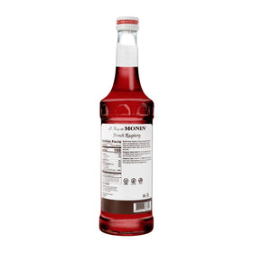 Monin French Raspberry Syrup pouring into a glass for lattes and iced cocktails.