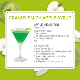 Monin Granny Smith Apple Syrup next to a tea cup enhances iced tea flavor.