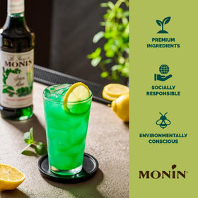 Monin Green Mint Syrup with mint garnish in a cocktail setting.