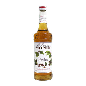 Monin hazelnut syrup bottle close-up for rich coffee and dessert flavor