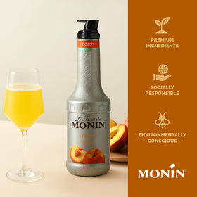 Monin Peach Purée bottle beside lemons for lemonade versatility