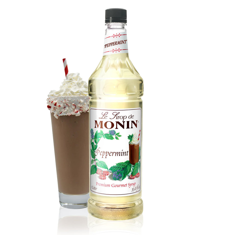 Monin Peppermint Syrup bottle pouring into hot cocoa for a refreshing mint finish.