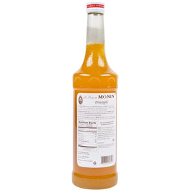 Pouring Monin Pineapple Syrup into a glass for drinks
