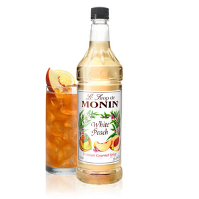 Monin White Peach Syrup bottle displayed for peachy cocktails and beverages.