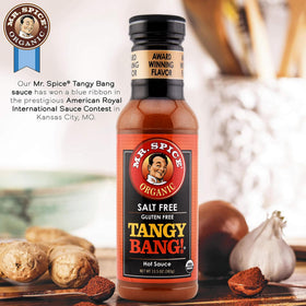 Pouring Tangy Bang from a bottle shows bright, tangy heat for wings and tacos.