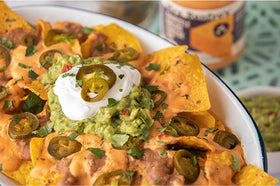 Creamy dip served in a bowl with nachos for dipping.