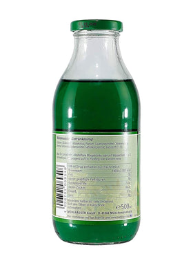 Pouring Muehlhaeuse Waldmeister Syrup into a glass for a vibrant drink.