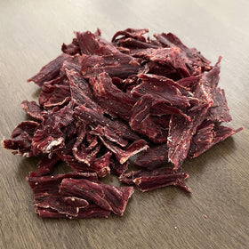 Macro texture detail of MV Vargas California Dry Beef Jerky Original emphasizing tough chew and lasting savor.