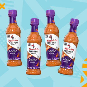 Close-up glaze on grilled meat with Nando's sauce.