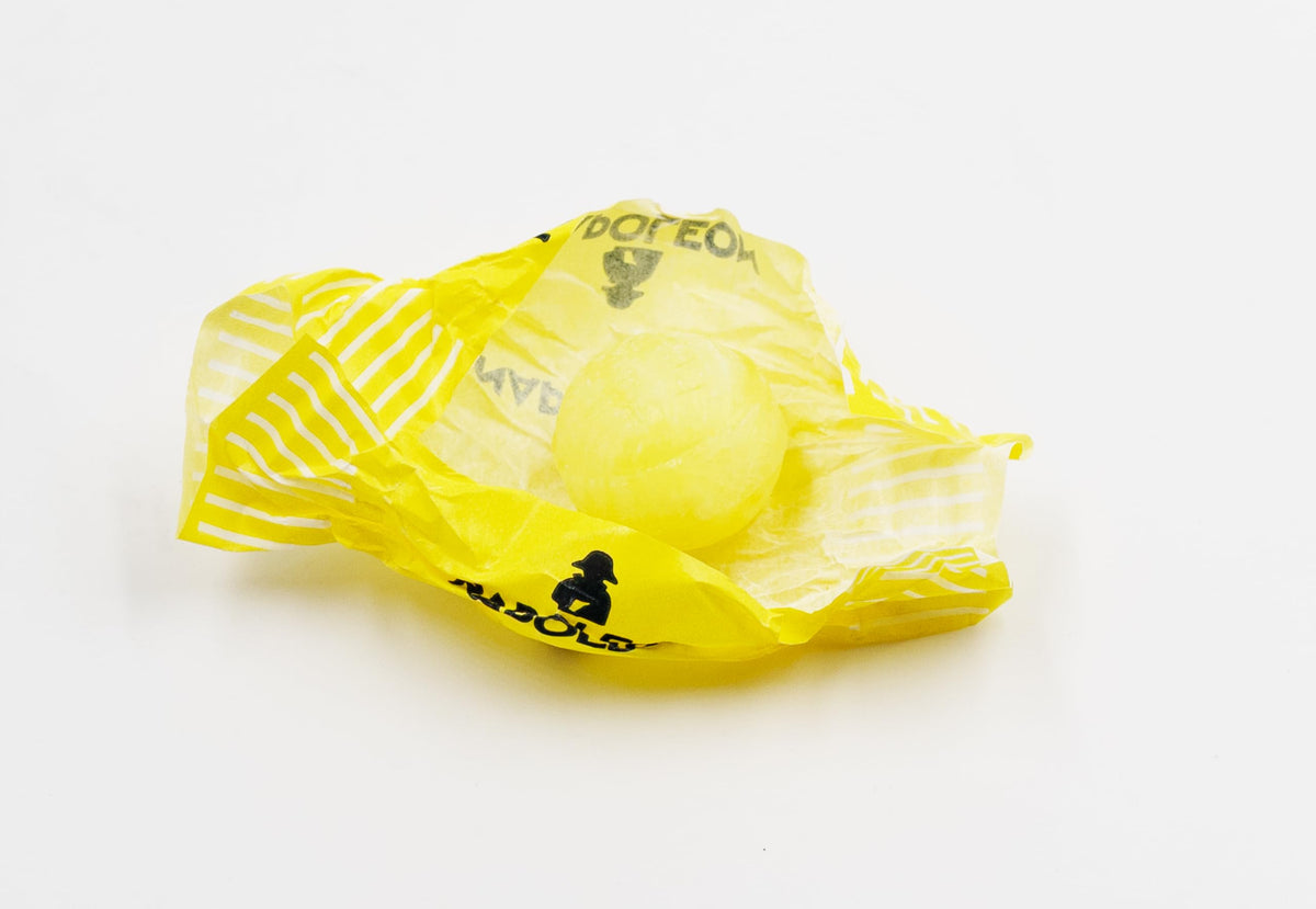 Napoleon Candy Lemon Balls yellow candy close-up on a glossy surface
