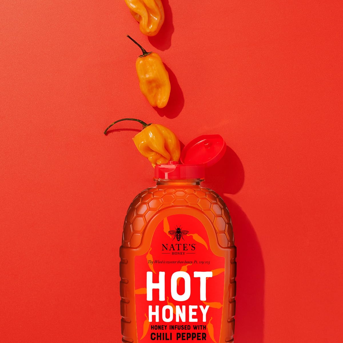 Close-up of Nate's Hot Honey showing habanero pepper flecks in golden honey.