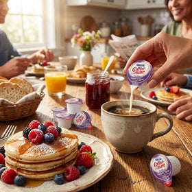 Nestle Coffee mate liquid creamer singles in table-top display for breakroom convenience.
