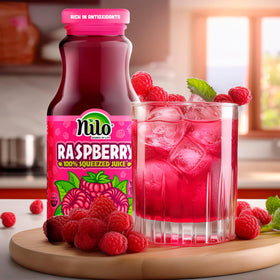 NILO Raspberry Juice poured into a glass showing fresh ingredients