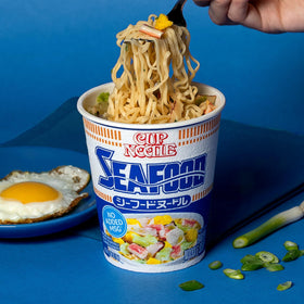 Nissin Cup Noodles Seafood adding water step emphasizes instant preparation with boiling water.
