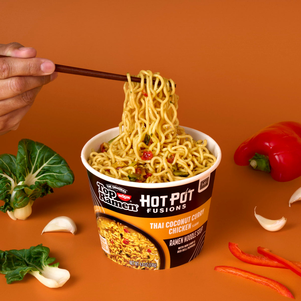 NISSIN Top Ramen Hot Pot Fusions Thai Coconut Curry Chicken includes bok choy and peppers for vibrant flavor.