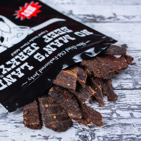 No Mans Land Hot jerky bag on table, ready for travel and on-the-go fueling.