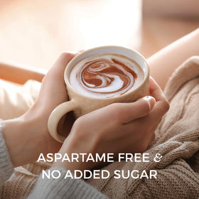 Stirring NOMU Skinny hot chocolate with a spoon for smooth texture.