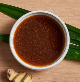 Nong's Khao Man Gai sauce bottle with woman-owned branding.