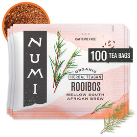 Numi Rooibos tea bags beside a warm amber cup for a caffeine-free sip