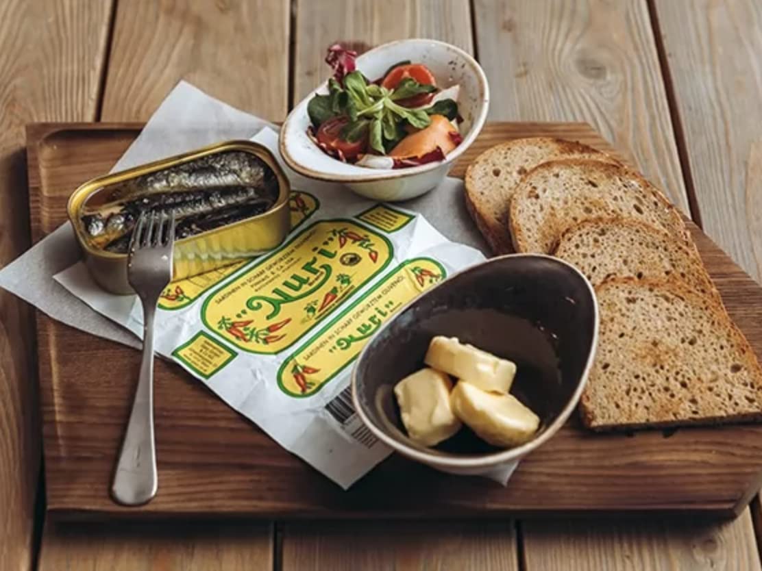 Nuri sardines in serving bowl showcase vibrant sauce and texture.