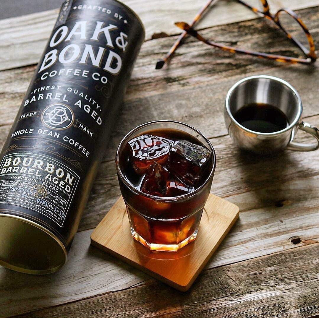 Oak & Bond bourbon barrel aging process depicted, infusing depth and warm notes for nuanced espresso.