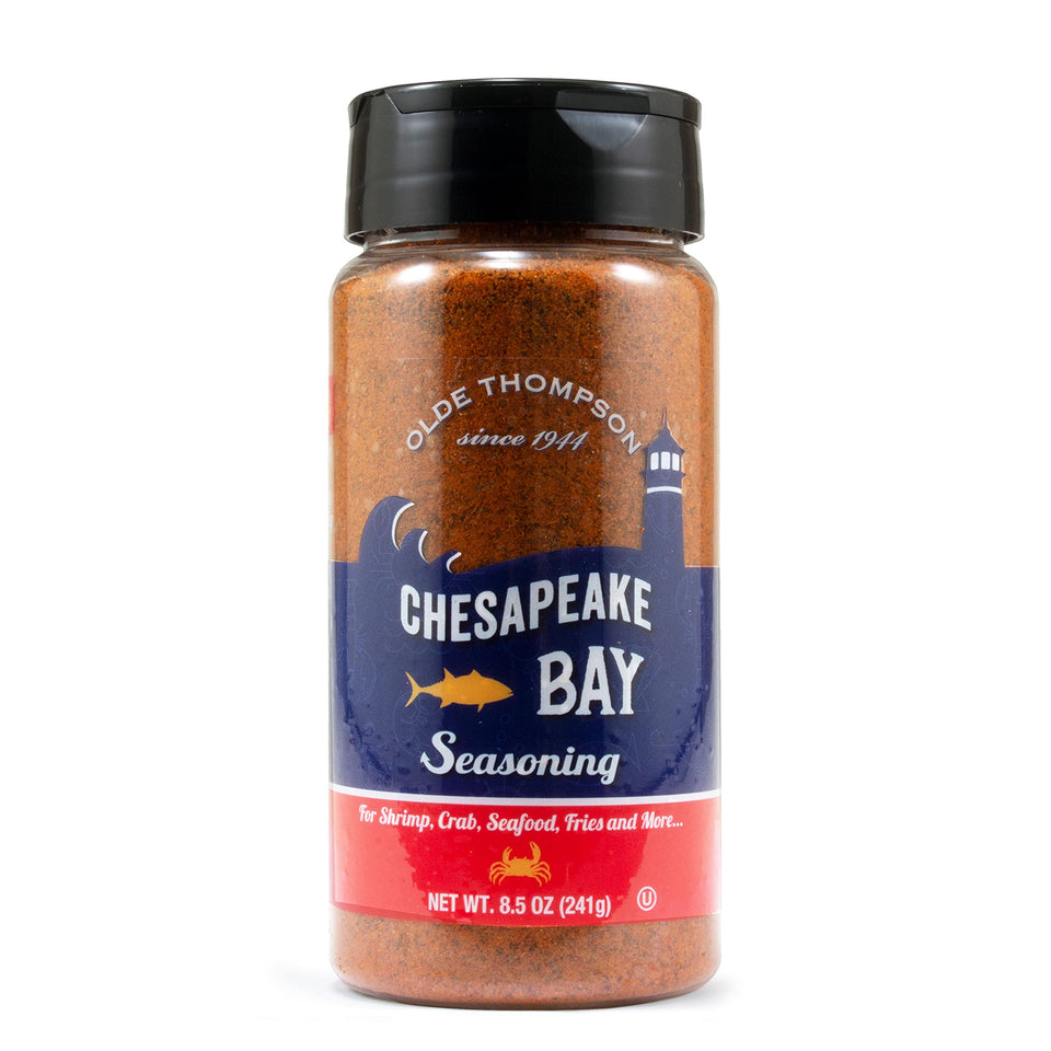 Olde Thompson Chesapeake Bay Seasoning bottle pouring over seafood for bold flavor