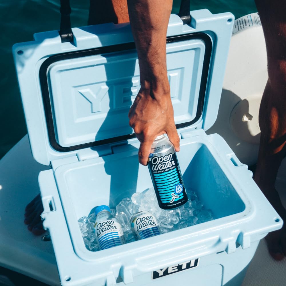 Open Water hand holding a 16oz aluminum bottle of sparkling water