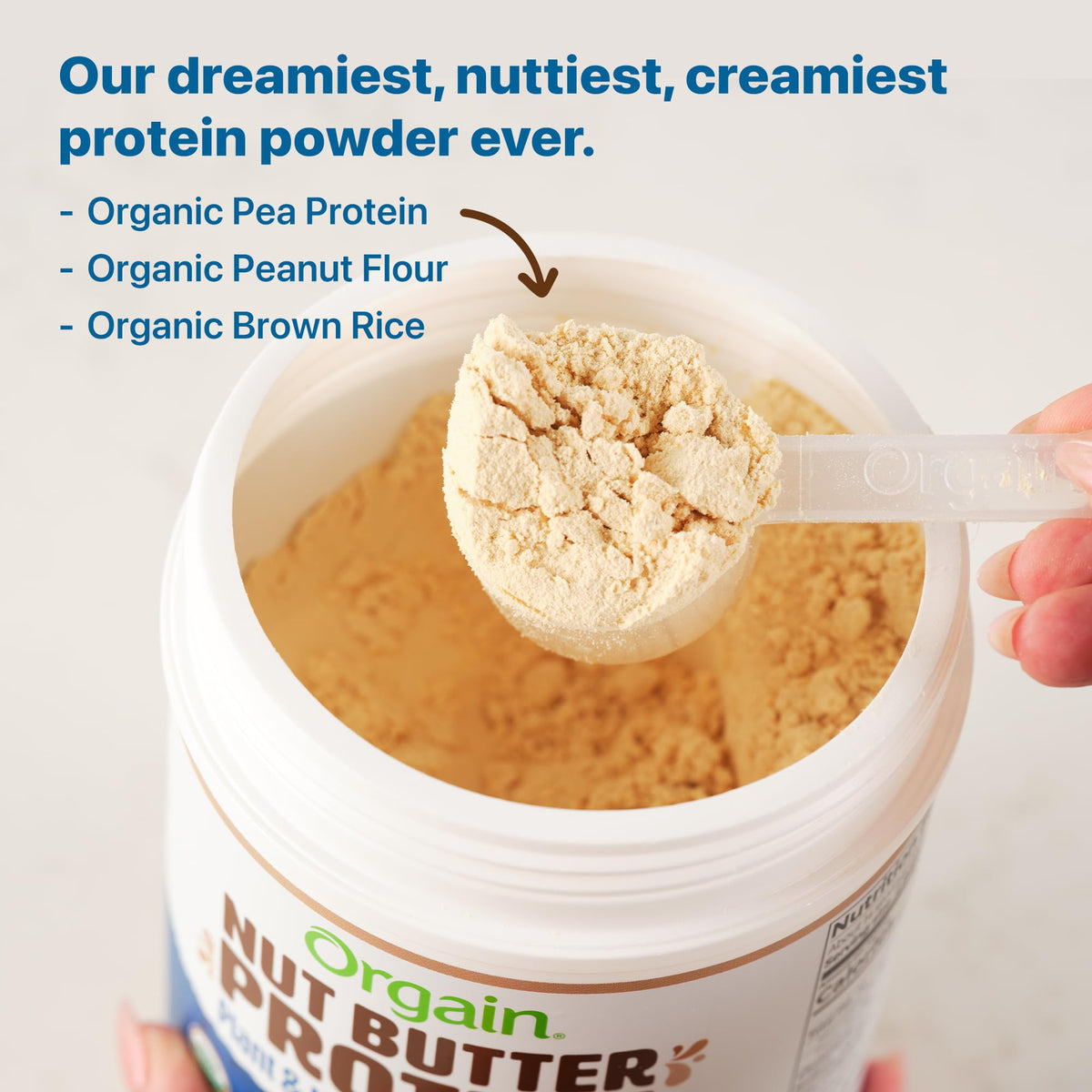 Orgain Vanilla Almond Butter Protein Powder being poured into a blender bottle.