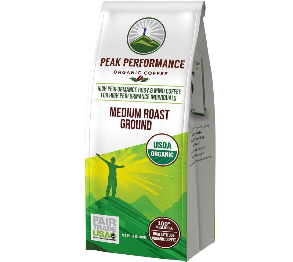 Peak Performance coffee bag 12 oz on countertop, highlighting organic and fair trade credentials.