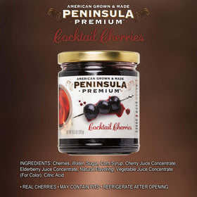 Peninsula Premium Cocktail Cherries jar close-up showing silky syrup for cocktails.