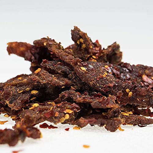 Pepper Joe’s Reaper jerky heat close-up showing fiery peppers and glossy glaze
