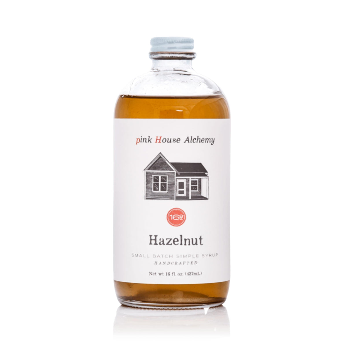 Pink House Alchemy Hazelnut Simple Syrup bottle pour enhances coffee and cocktails.